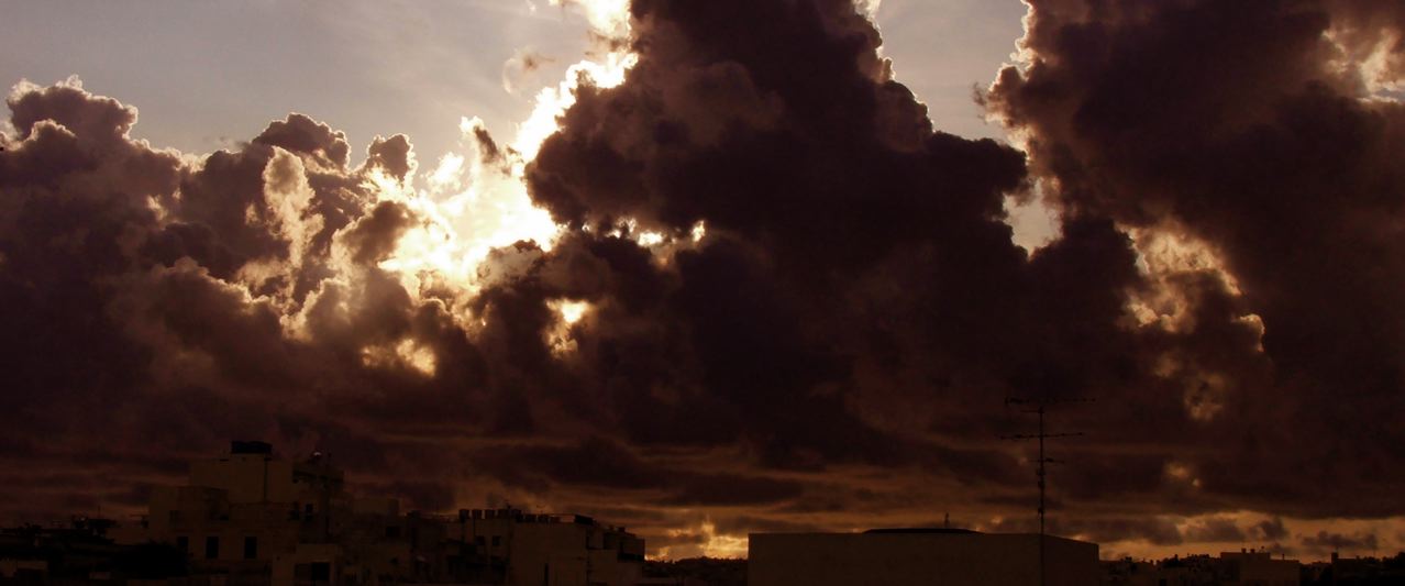 How do stratus clouds form as dark grey, low-level layers stretching across a moody Australian sky during overcast weather.