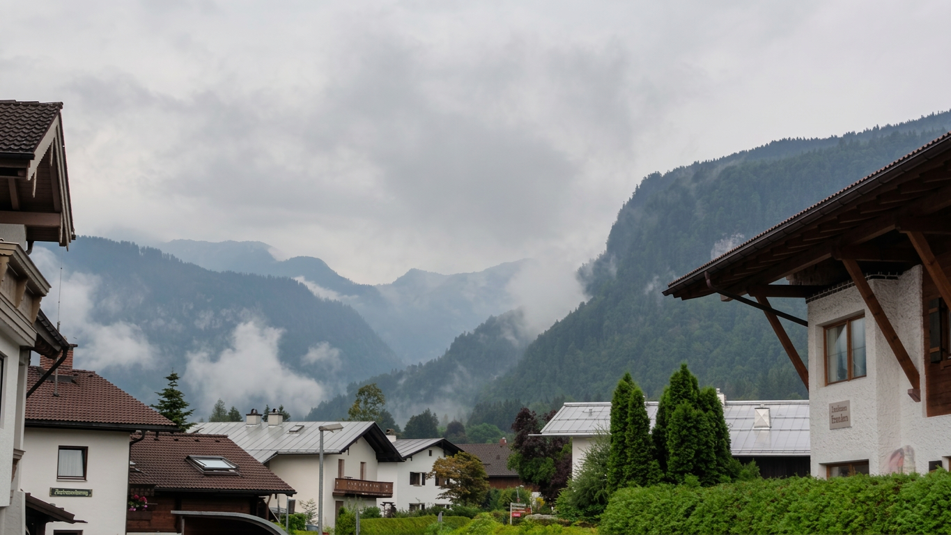 Nimbostratus cloud formation creating a thick, dark grey deck over the mountains and valley of Schönau am Königssee.