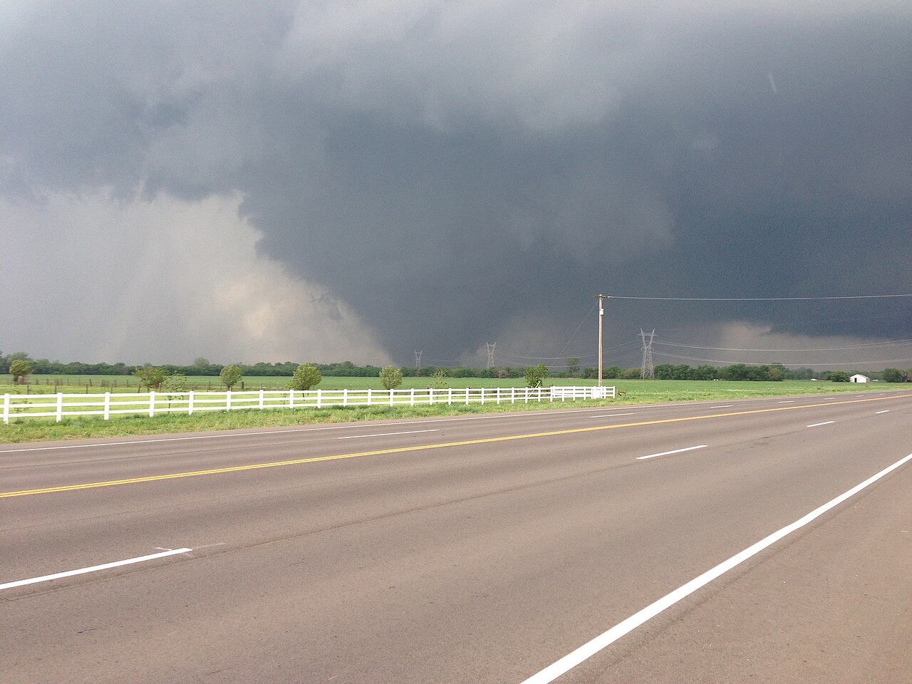 Dark, menacing storm clouds over a rural road and field, symbolizing the shifting threat of Tornado Alley moving east. Dark, menacing storm clouds over a rural road and field, symbolizing the shifting threat of Tornado Alley moving east.