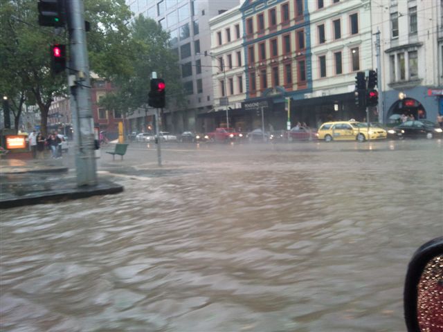 Melbourne street flooded with murky water, cars partially submerged, illustrating the 2010 hailstorm's impact. Melbourne street flooded with murky water, cars partially submerged, illustrating the 2010 hailstorm's impact.