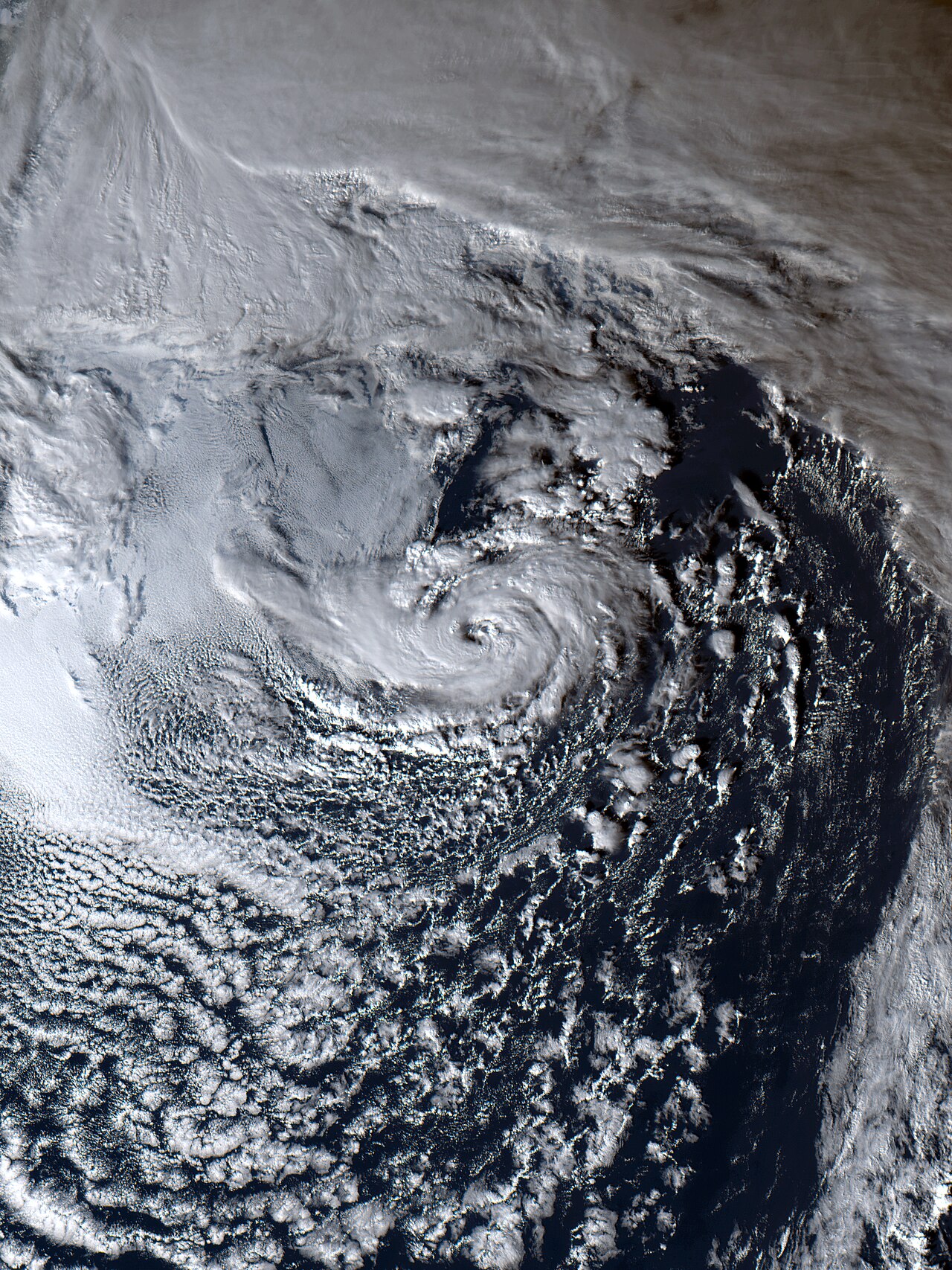 Satellite view of a swirling subtropical storm or hybrid cyclone over dark ocean waters, illustrating its formation. Satellite view of a swirling subtropical storm or hybrid cyclone over dark ocean waters, illustrating its formation.