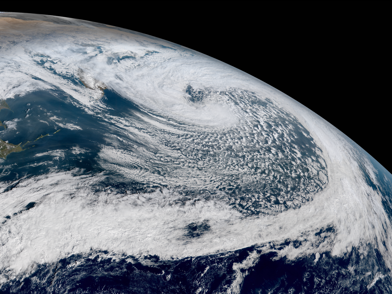 Satellite view showing a massive, swirling bomb cyclone cloud formation over the ocean, illustrating explosive cyclogenisis. Satellite view showing a massive, swirling bomb cyclone cloud formation over the ocean, illustrating explosive cyclogenisis.