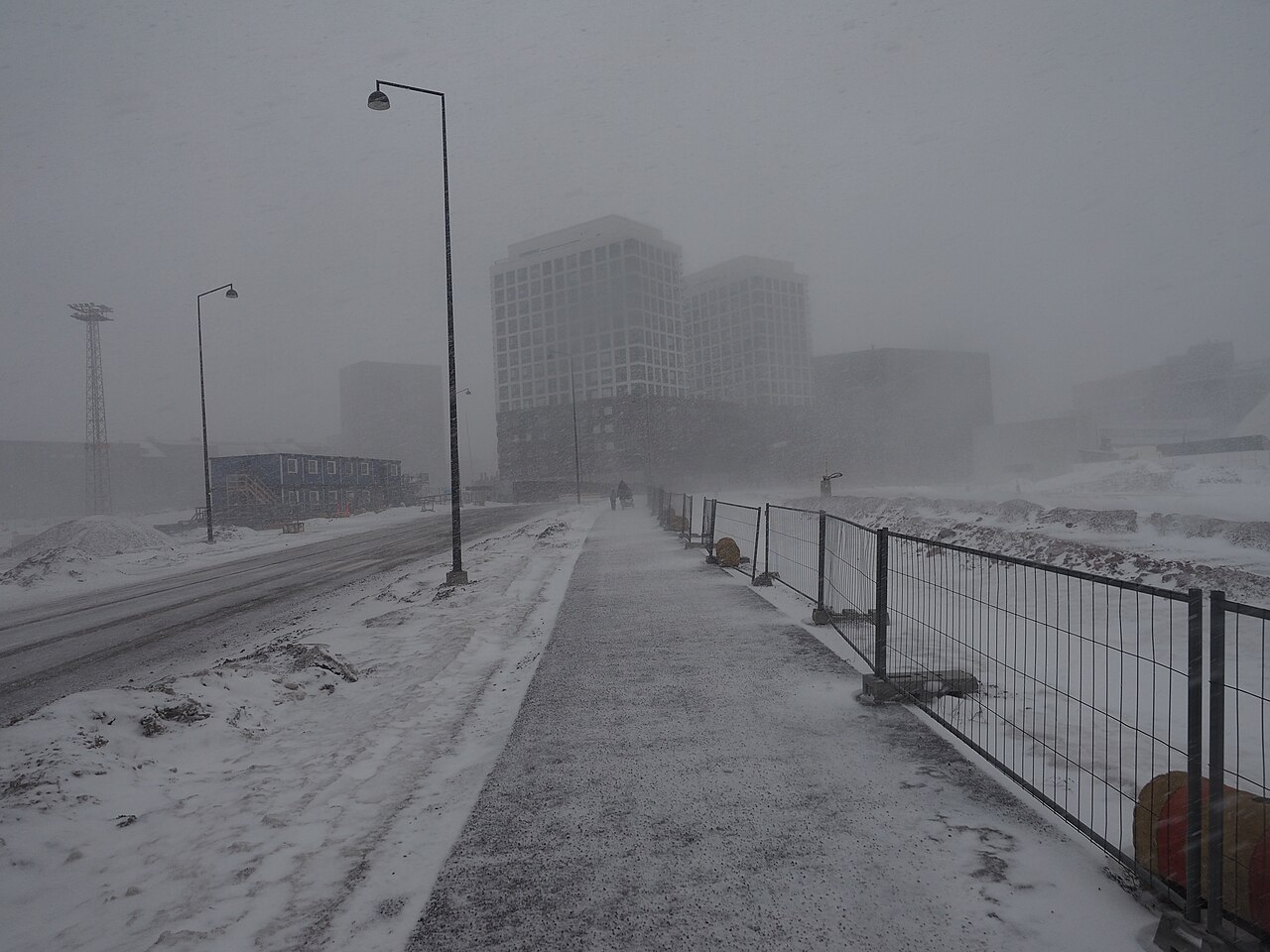 Urban street during a blizzard, with heavy snowfall, low visibility, and snowdrifts illustrating blizzard conditions. Urban street during a blizzard, with heavy snowfall, low visibility, and snowdrifts illustrating blizzard conditions.